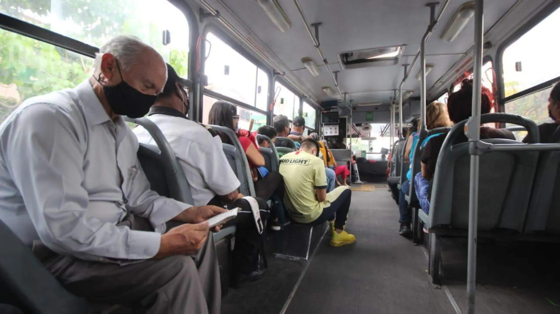 Personas en el transporte público usando cubrebocas